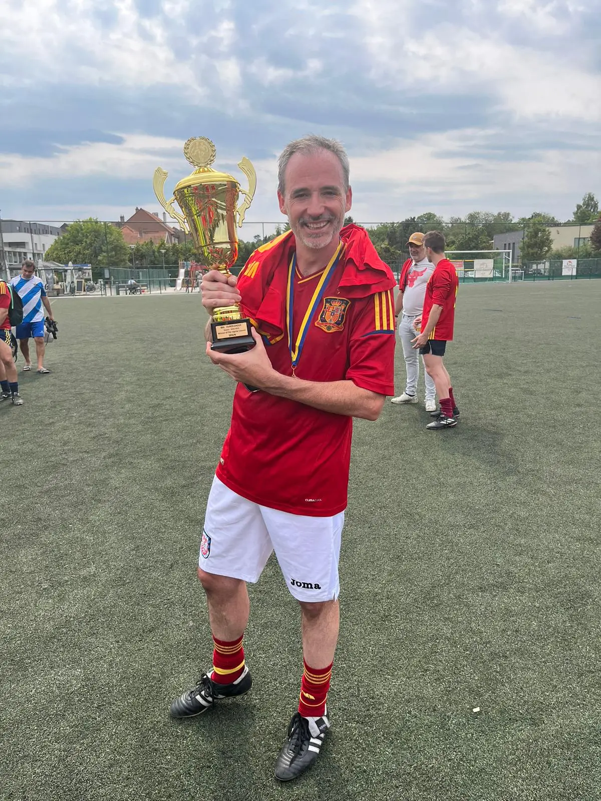 Jugador veterano de La Roja muestra el trofeo tras el 15.º aniversario
