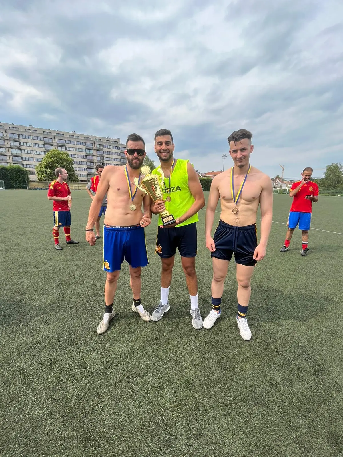 Tres jugadores celebran con un trofeo sobre el césped