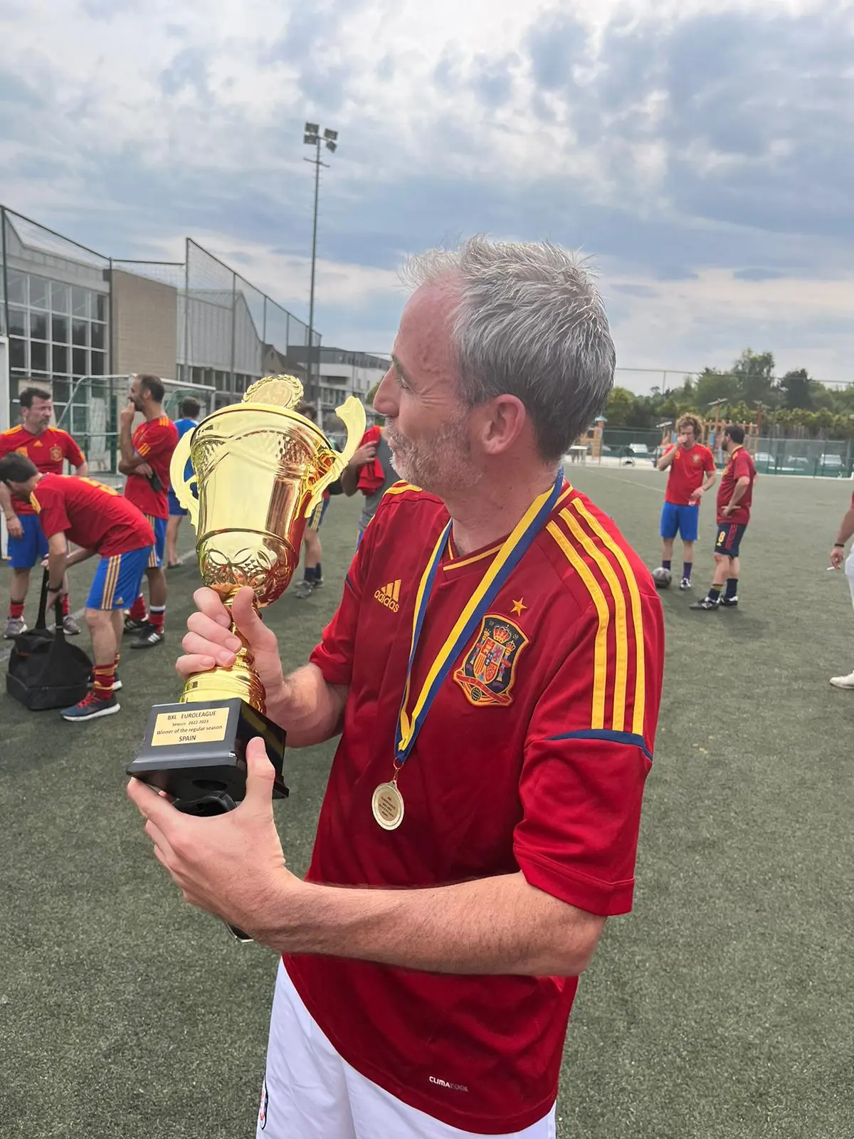Detalle de un jugador observando el trofeo con medalla al cuello