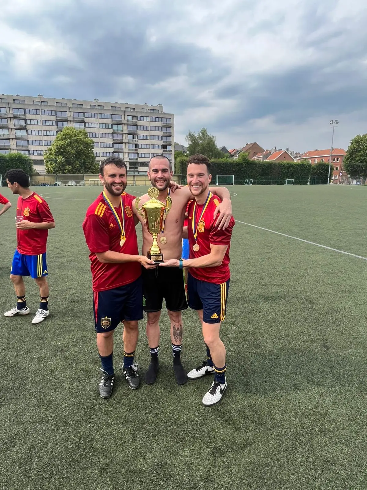 Tres jugadores sonríen junto al trofeo del 15.º aniversario