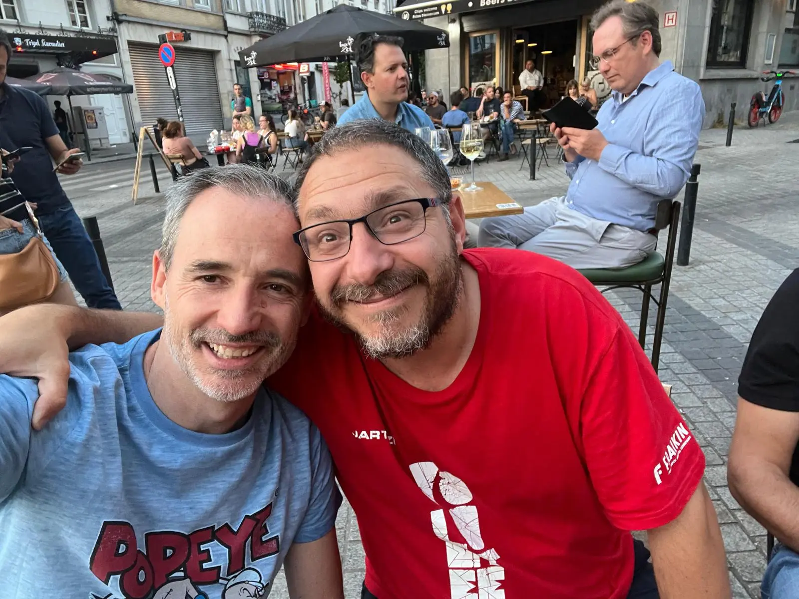 Dos miembros del club posan juntos en una terraza de Bruselas